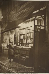 Examining a book outside a second hand bookshop on a wet winter evening, Bloomsbury